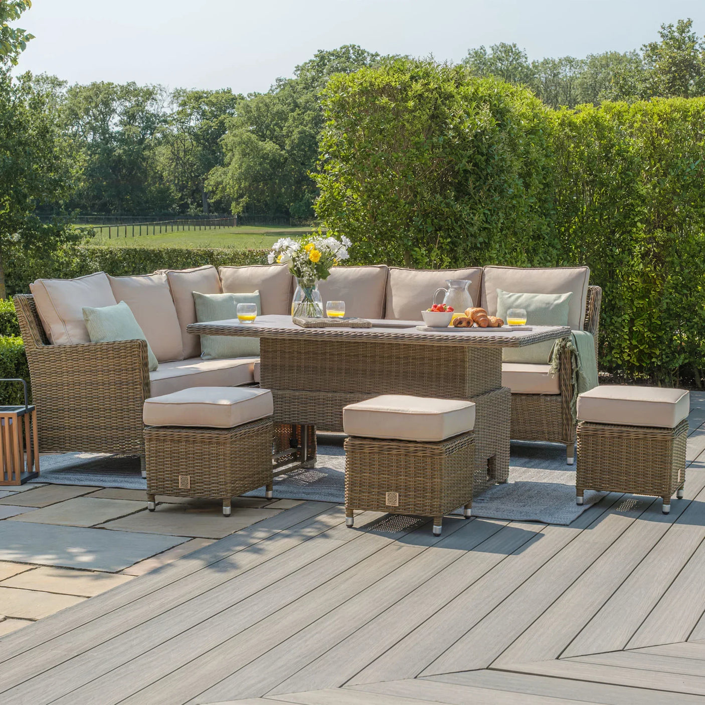 Rattan corner garden furniture set with beige cushions, glass-topped table and matching stools