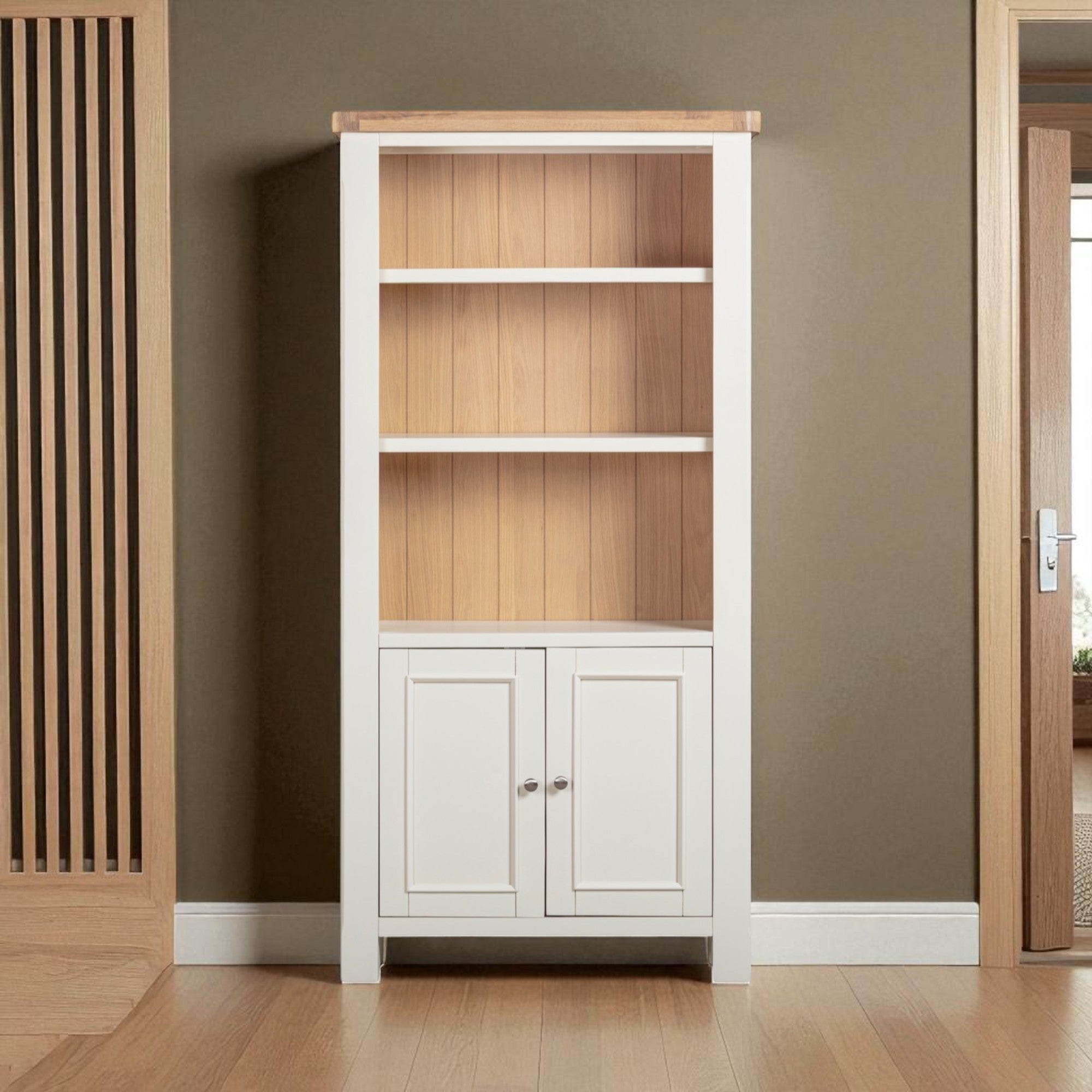 Tall bookshelf with wooden shelves and white base cabinet against a brown wall.