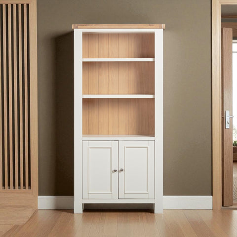 Tall bookshelf with wooden shelves and white base cabinet against a brown wall.