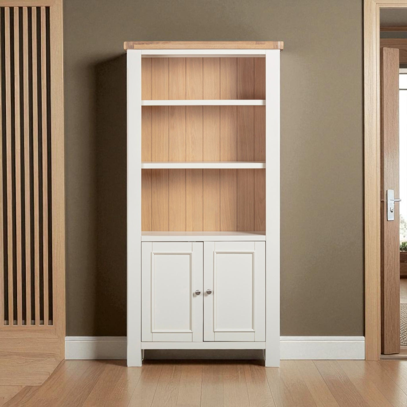 Tall bookshelf with wooden shelves and white base cabinet against a brown wall.