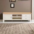 White TV stand with wooden top in a room with a brown wall and rug.