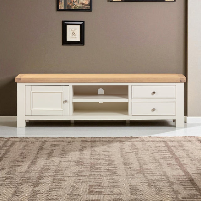 White TV stand with wooden top in a room with a brown wall and rug.
