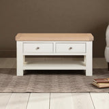 Wooden coffee table with two drawers on a wooden floor.