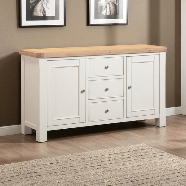 White sideboard with wooden top in a room with framed pictures on the wall.