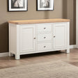 White sideboard with wooden top in a room with framed pictures on the wall.