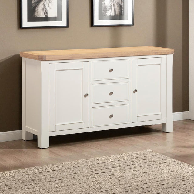 White sideboard with wooden top in a room with framed pictures on the wall.