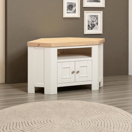 Corner TV stand with wooden top and white base in a room with framed pictures on the wall.