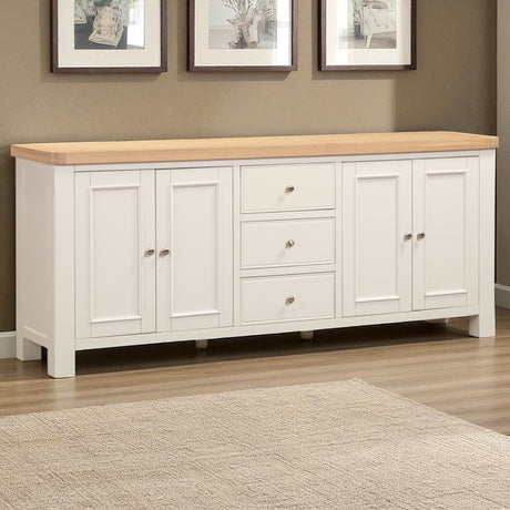 White sideboard with wooden top in a room with framed pictures on the wall.