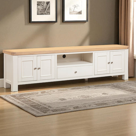 White TV stand with wooden top in a room with framed pictures on the wall.