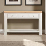 White console table with wooden top against a wall with framed pictures.