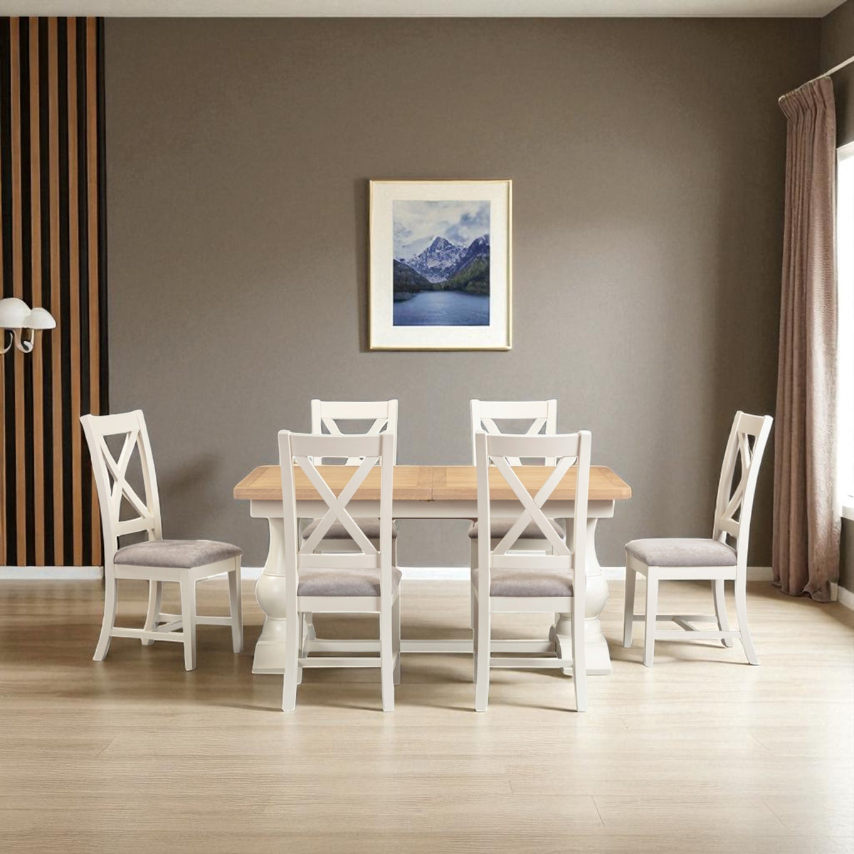 Dining room with a wooden table and white chairs against a gray wall with a framed picture.