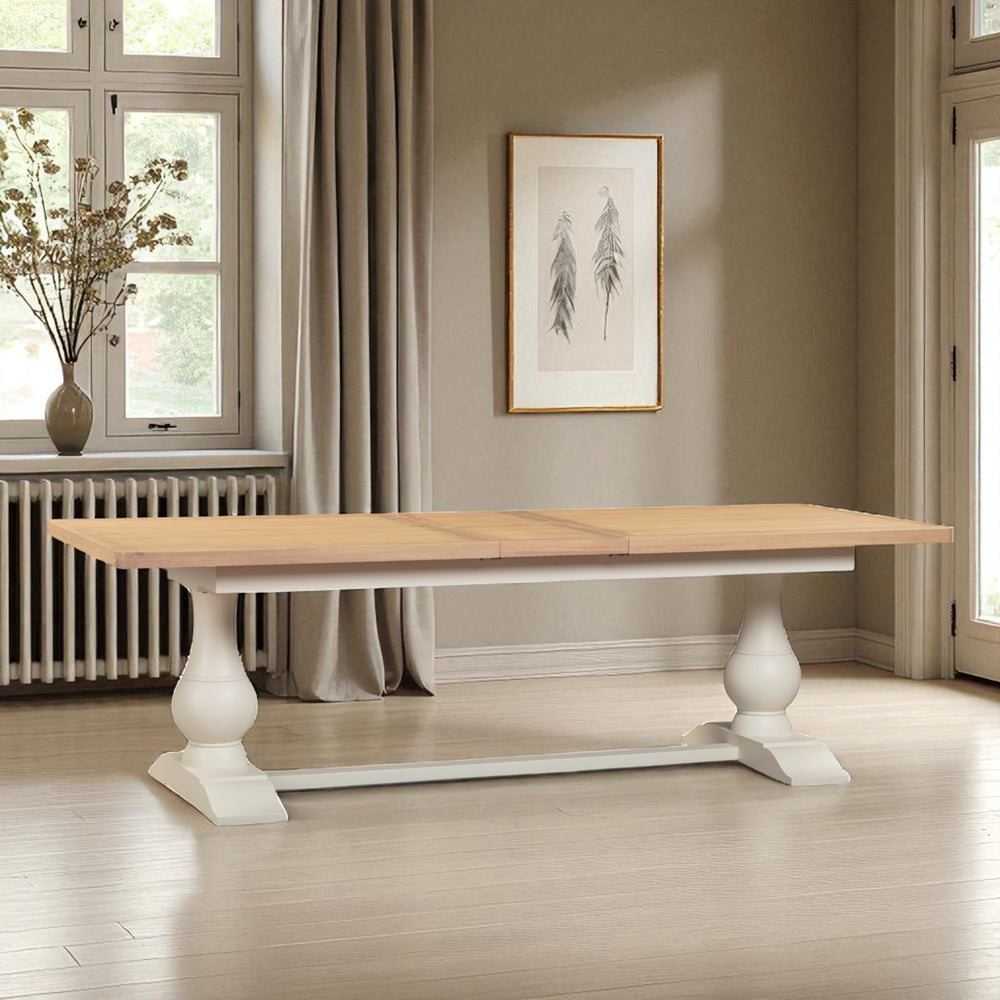 Wooden dining table with white legs in a room with windows and a radiator.