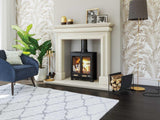 Modern living room with log burner fireplace, navy armchair, and patterned rug