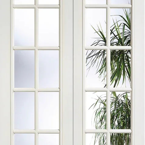 White moulded glazed door pair with clear glass panels and indoor plant reflection