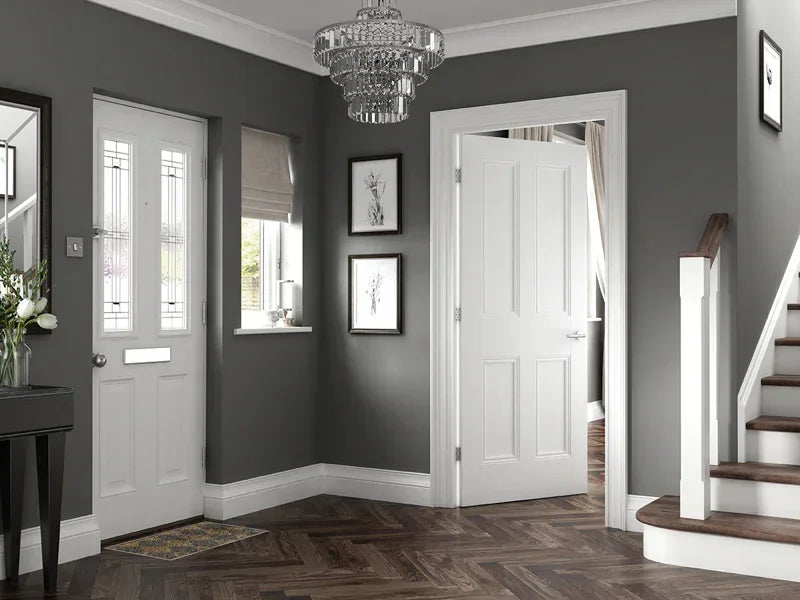 White interior door with four panels in modern grey hallway with wooden herringbone floor