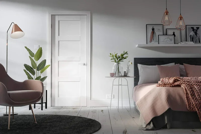 White shaker 4 panel interior door in modern bedroom with grey chair and pink bedding