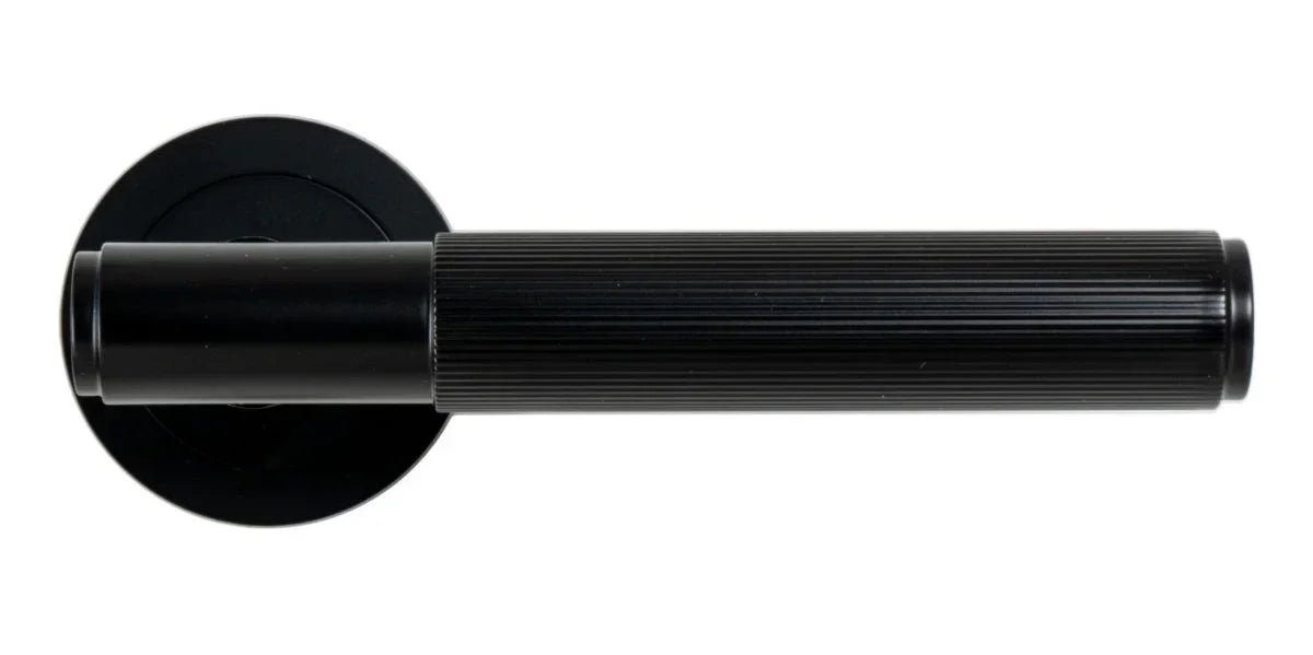 Matt black door handle with ribbed grip and round backplate, modern hardware detail