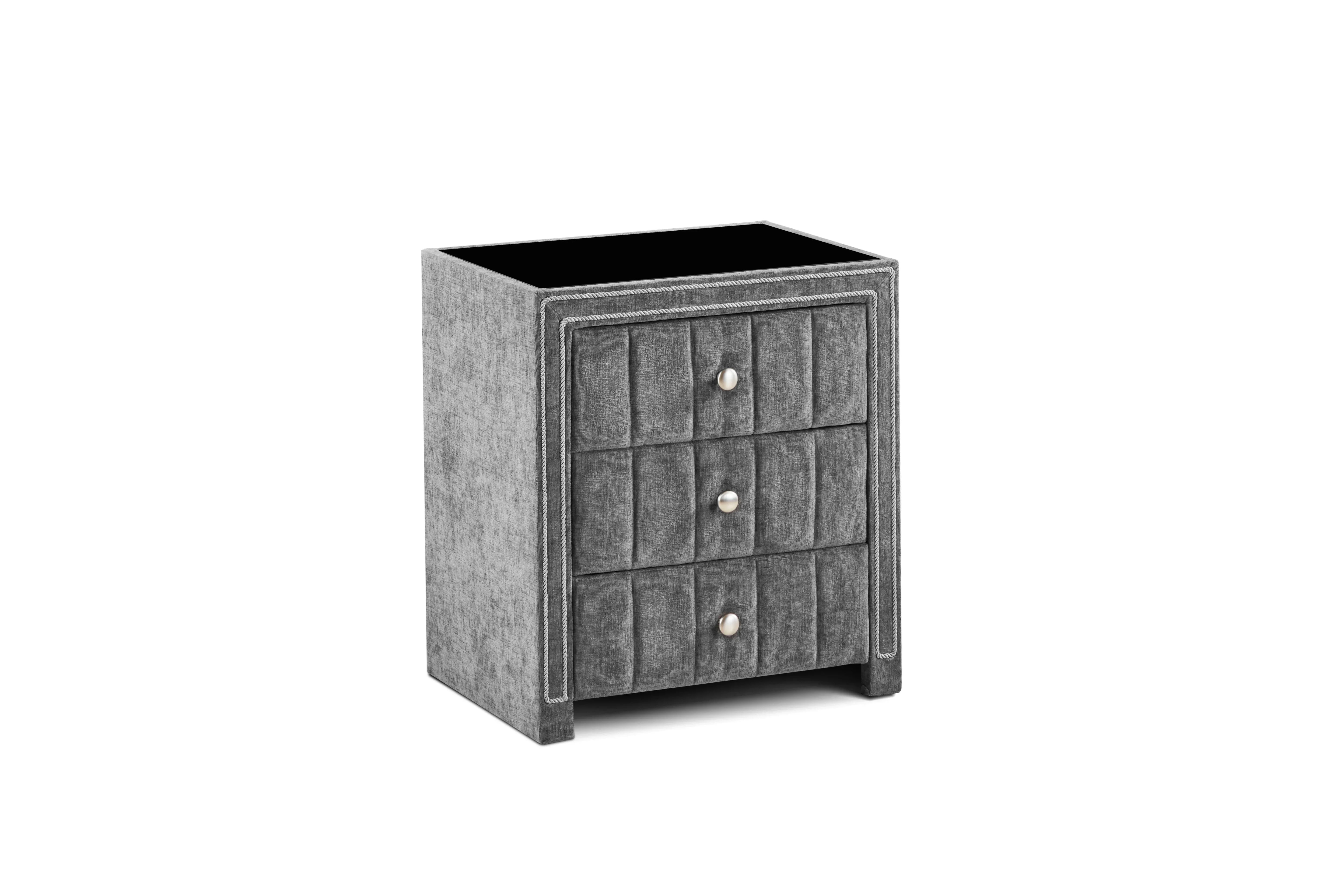 Grey fabric bedside cabinet with three drawers and silver handles, front angle view