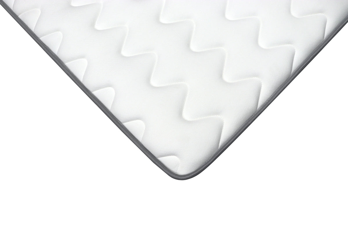 Corner detail of white mattress with quilted zigzag pattern and grey edge trim