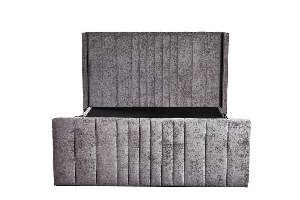 Grey upholstered storage bed frame with vertical panel detailing and open ottoman base