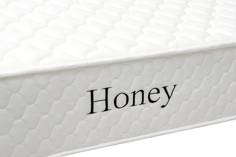 White quilted mattress side view with Honey text embroidered on fabric cover