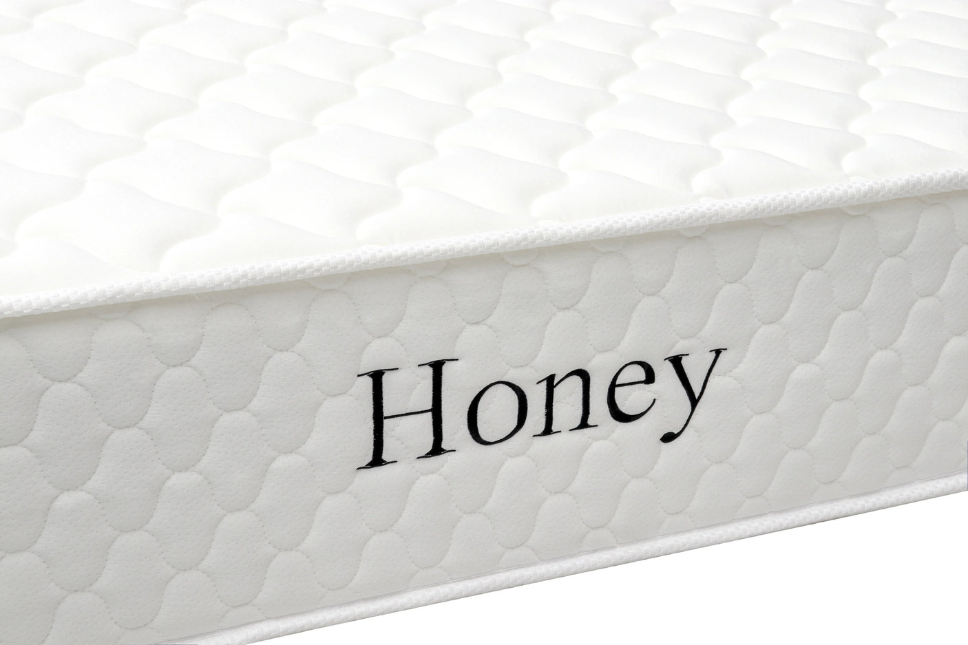 White quilted mattress side view with Honey text embroidered on fabric cover