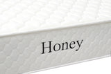 White quilted mattress side view with Honey text embroidered on fabric cover