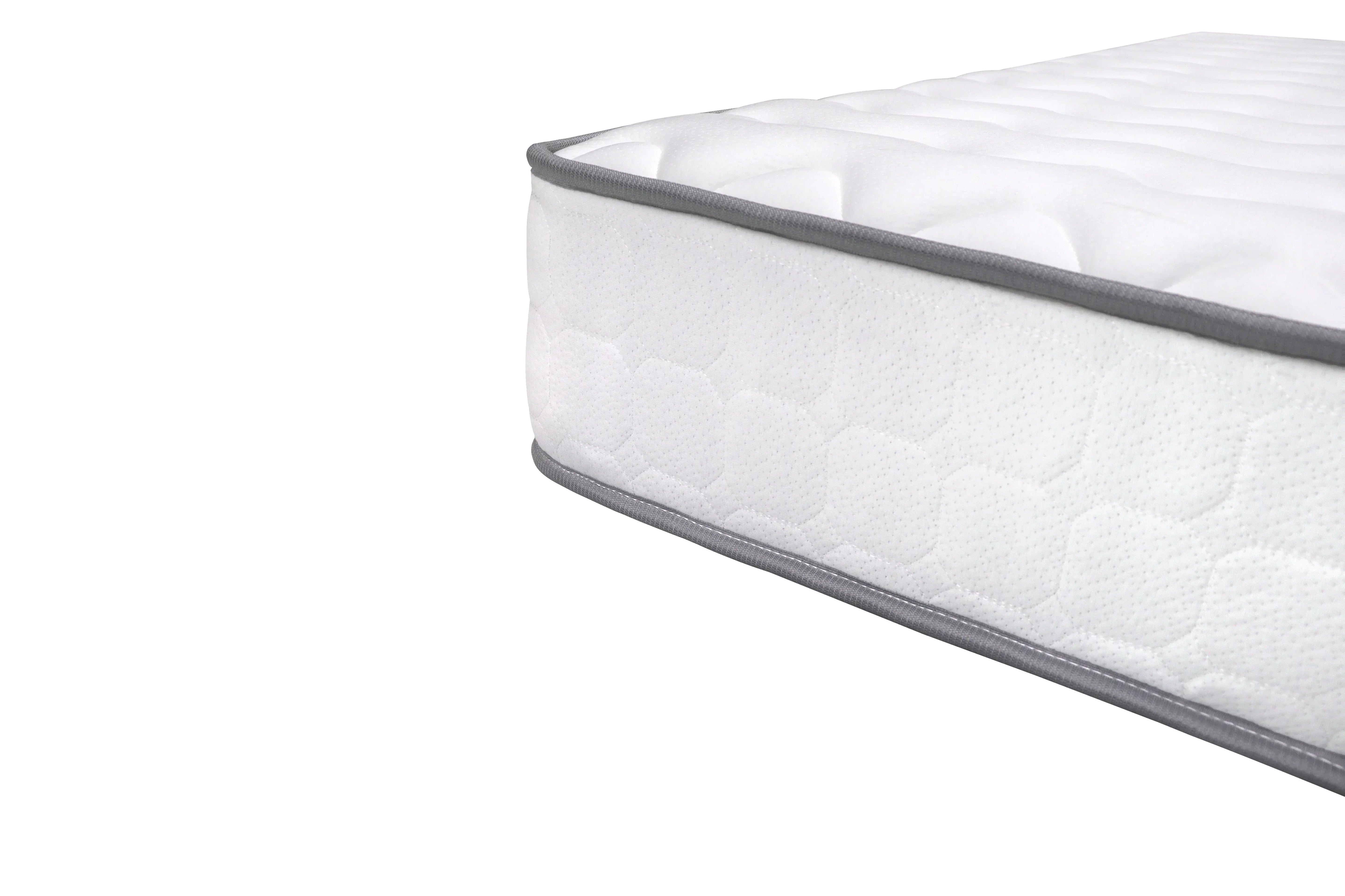 White mattress with quilted surface and grey trim closeup on corner
