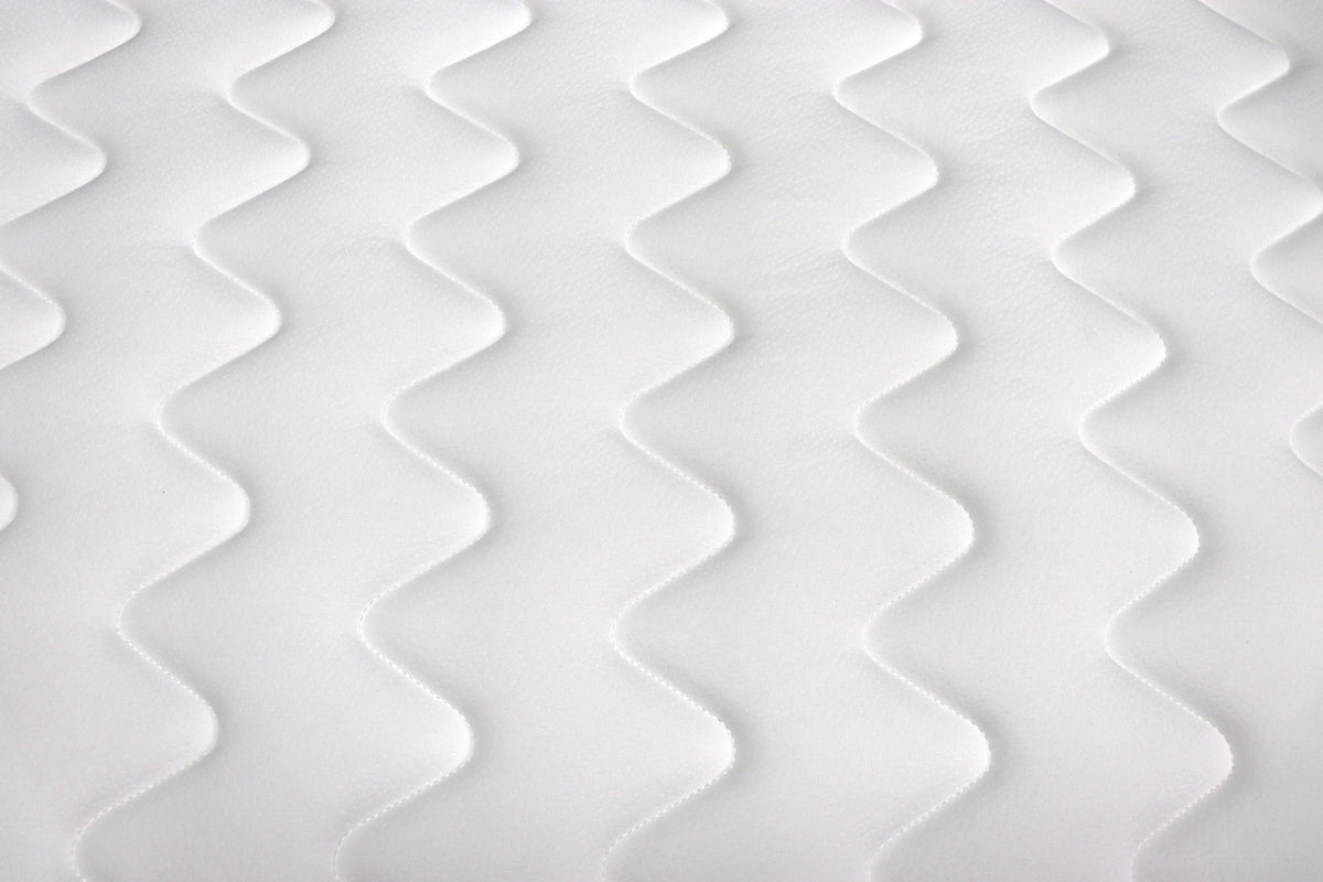 white mattress close-up with zigzag quilted stitching pattern