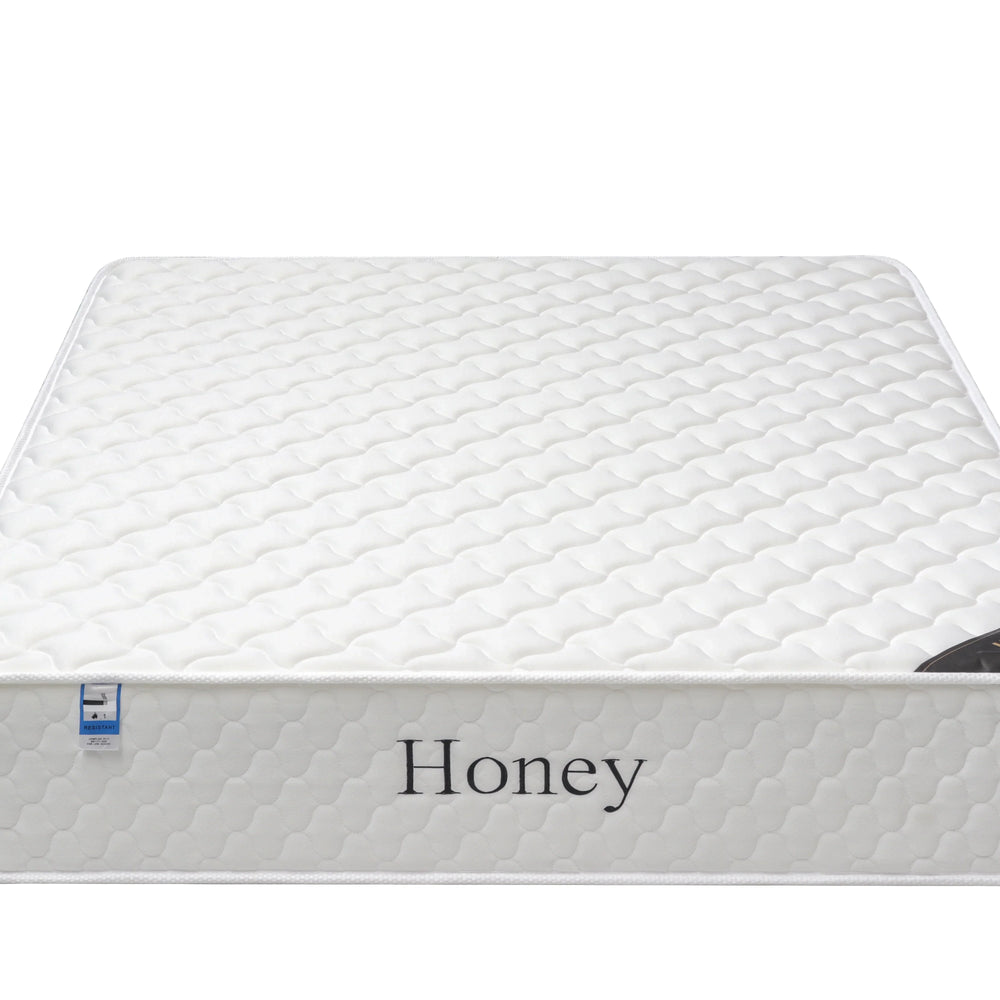 White honey mattress with quilted pattern and side label, front angle view