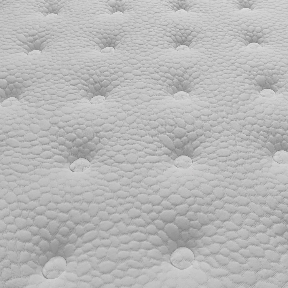 Close up of white mattress surface with tufted button design and textured fabric