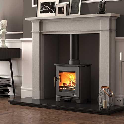 Modern wood burning stove with glass door in marble fireplace surround in living room