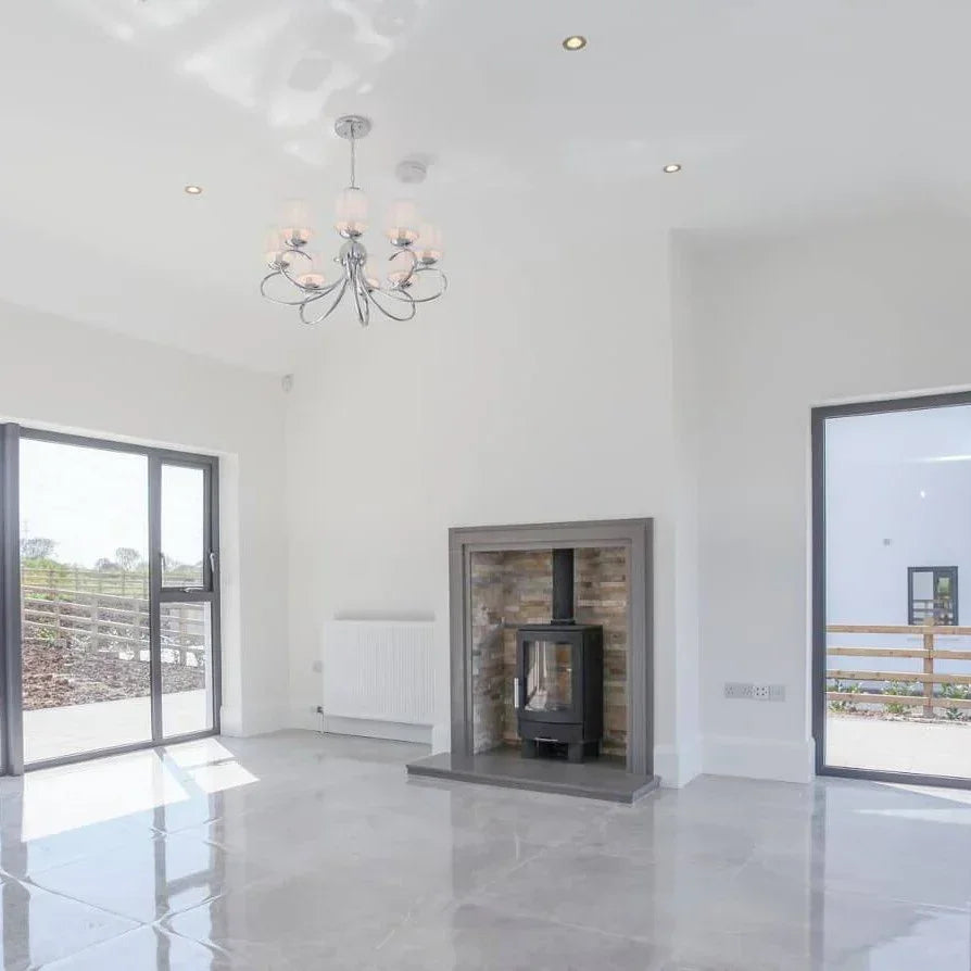 Modern living room with large windows, tiled floor and freestanding wood burning stove