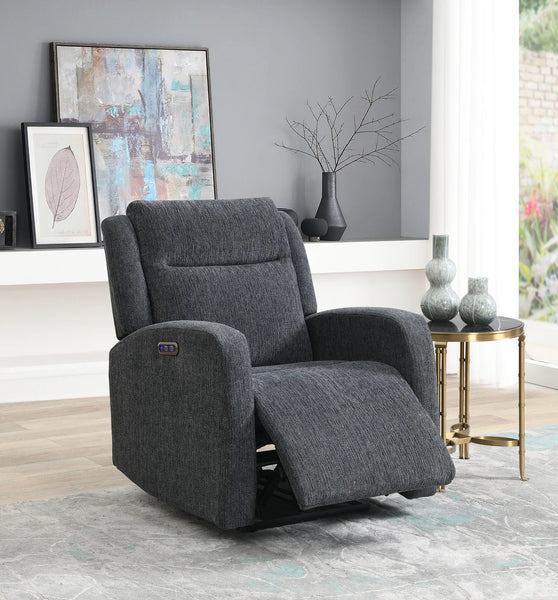 A dark gray upholstered recliner chair shown in a styled living room setting with a side table, framed wall art, and a window.