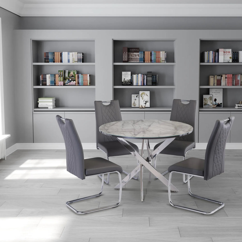 Dining area with a round table and four chairs in a room with bookshelves.