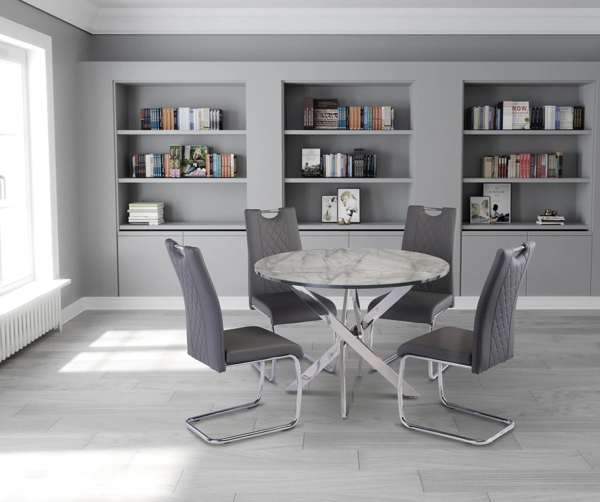Dining area with a round table and four chairs in a room with bookshelves.
