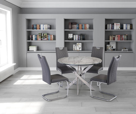 Dining area with a round table and four chairs in a room with bookshelves.