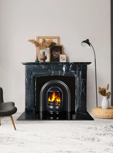 Black marble fireplace with modern fire insert and decorative vases in living room