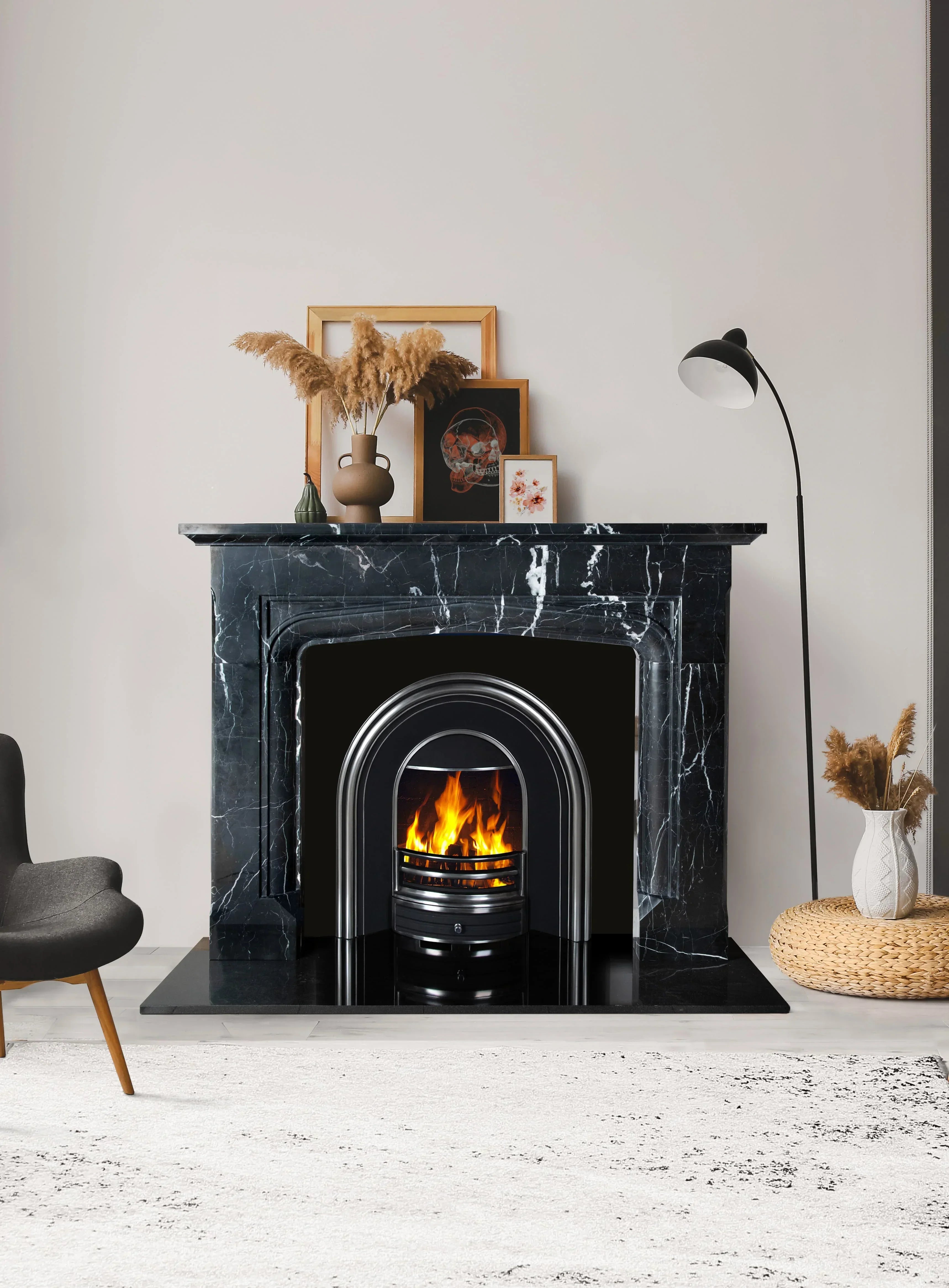Black marble fireplace with modern fire insert and decorative vases in living room