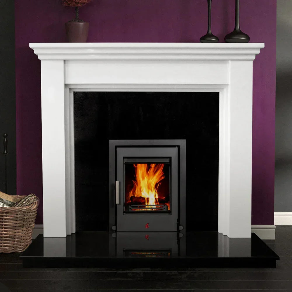 Polished polar white fireplace surround with inset wood burning stove against purple wall