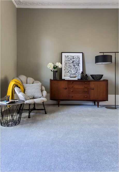 Grey carpet flooring with mid-century sideboard, accent chair, and floor lamp in living room