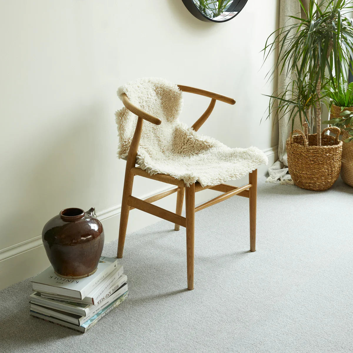 Dolomite stone carpet in living room with wooden chair, textured vase and indoor plants