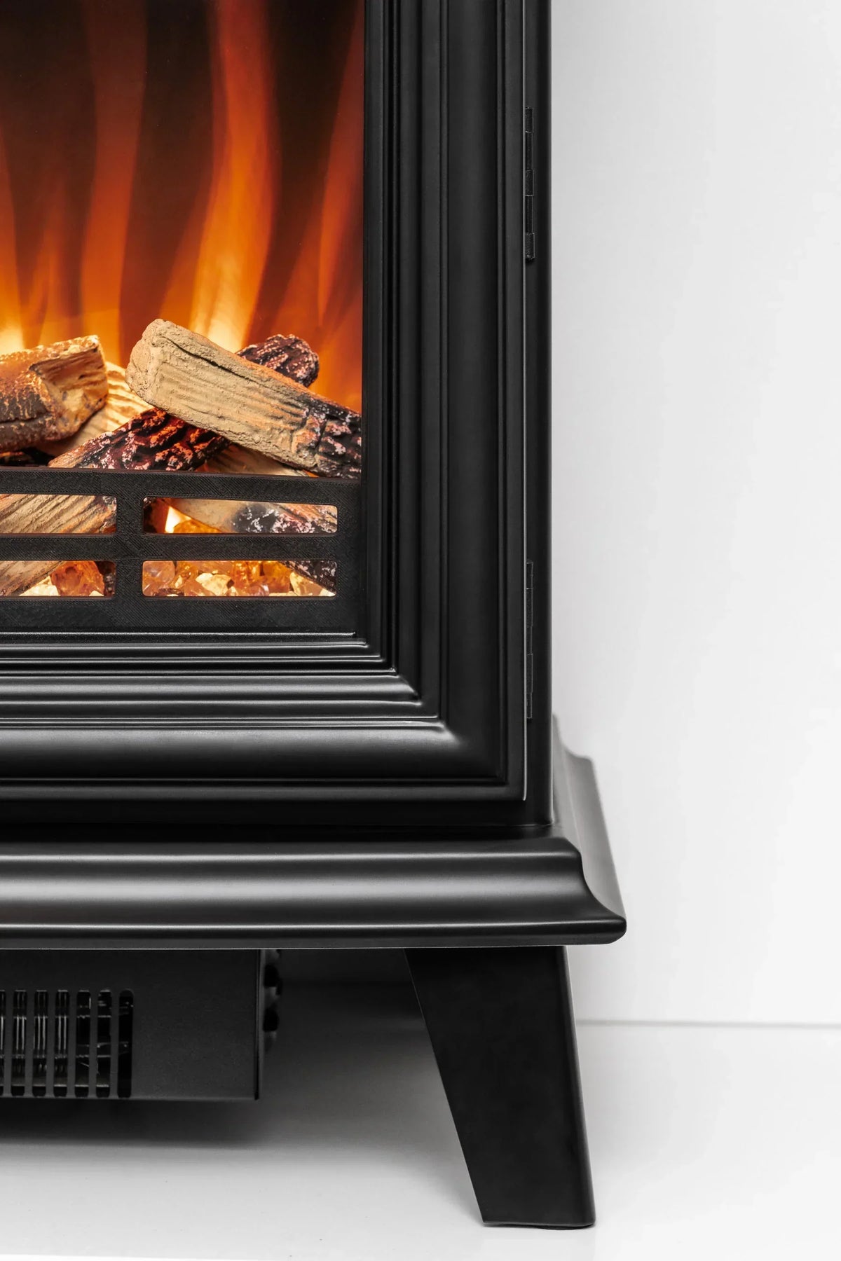 close view of electric fireplace heater with black frame and glowing faux logs