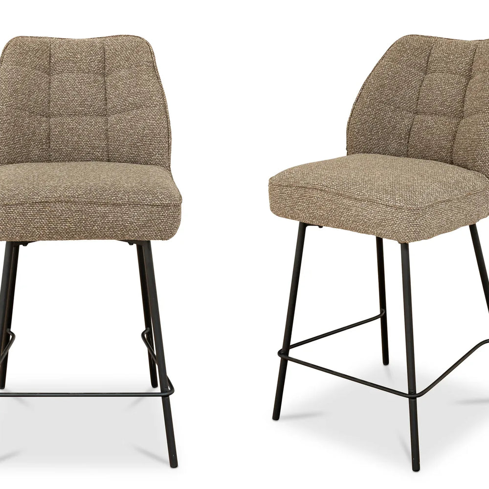 Two brown bar stools with quilted seats on a white background