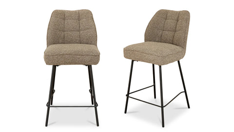 Two brown bar stools with quilted seats on a white background