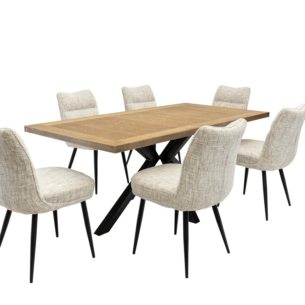 A 7-piece dining set featuring a rectangular light oak wood table with a black metal X-base and six upholstered dining chairs in a textured beige fabric with black legs, shown on a solid white background.