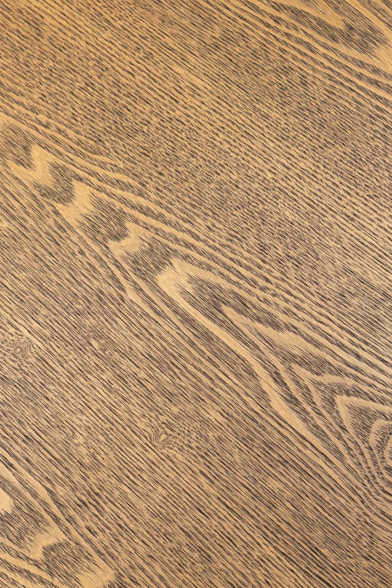 A close-up texture of a medium brown wood grain surface with natural light tan streaks and darker brown lines.