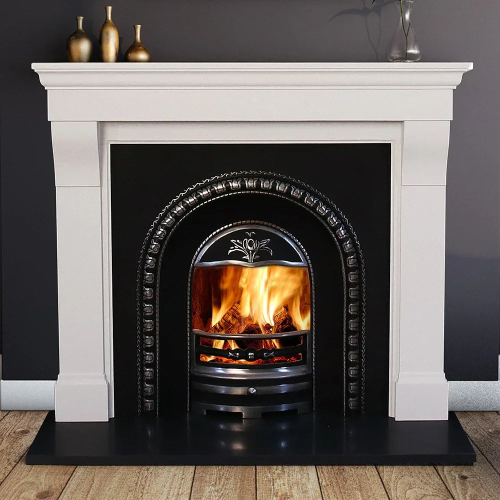 Cabra 54 limestone fireplace with black cast iron fire insert and burning logs