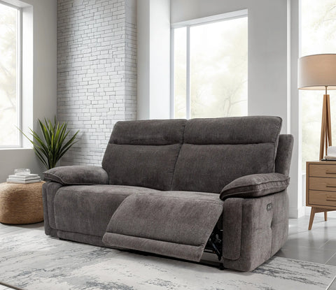 Gray sofa in a living room with large windows and a lamp.