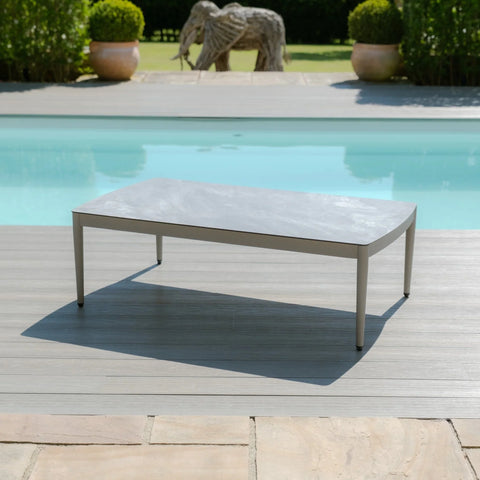 Grey outdoor coffee table with metal frame beside pool on wooden decking